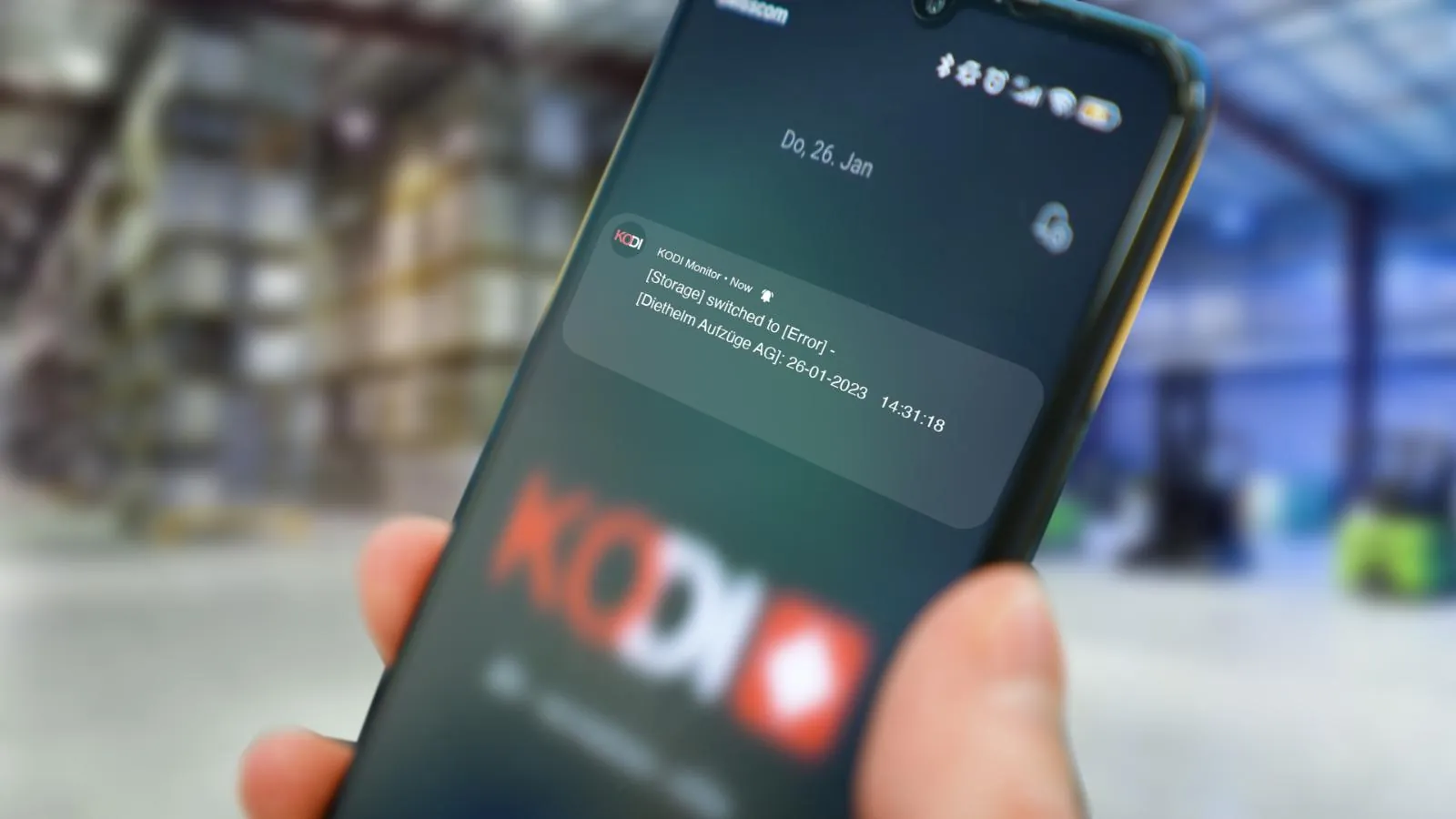 Smartphone mit einer KODI Push-Meldung in der Werkstatt